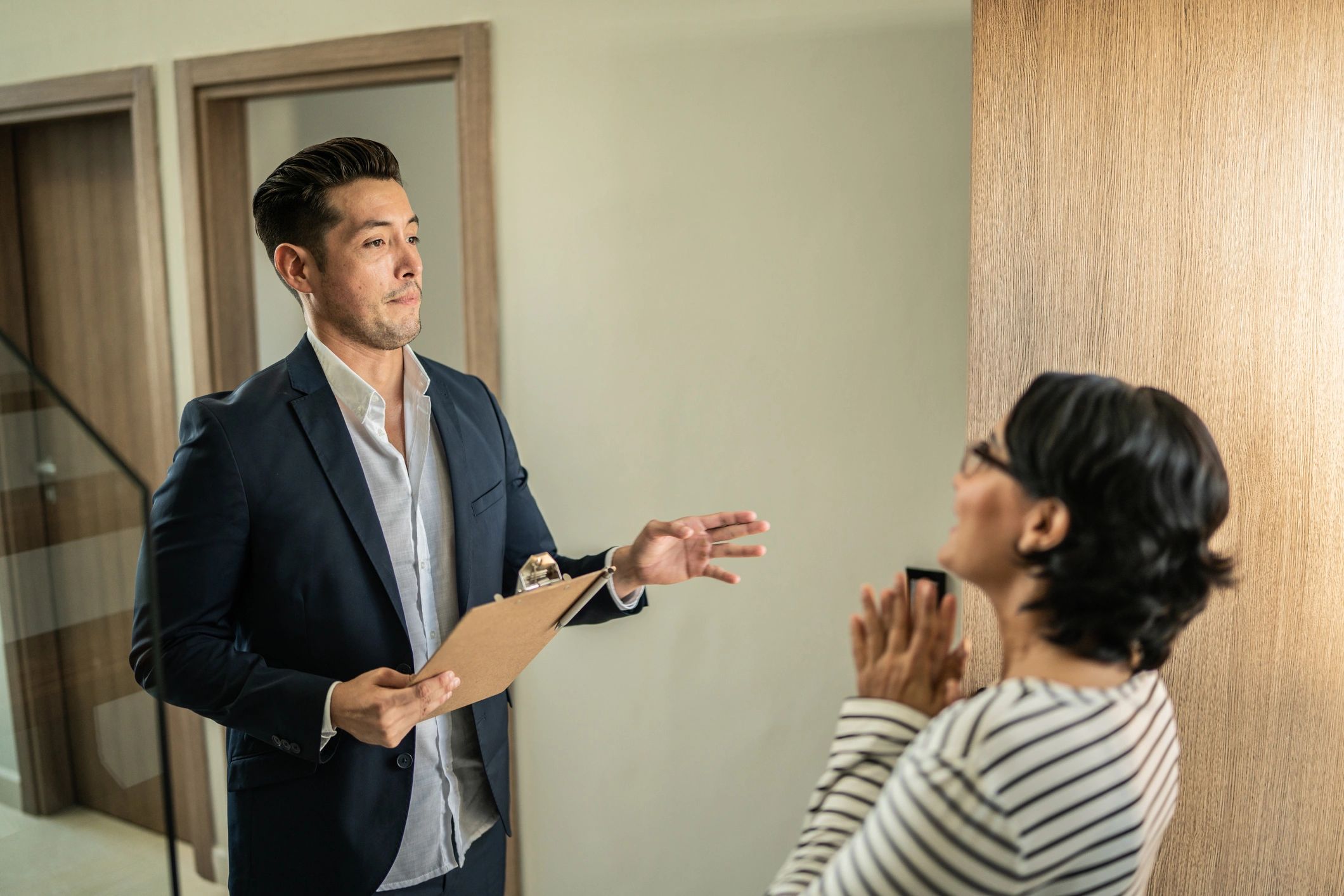 Real estate agent speaking with a client during a home tour