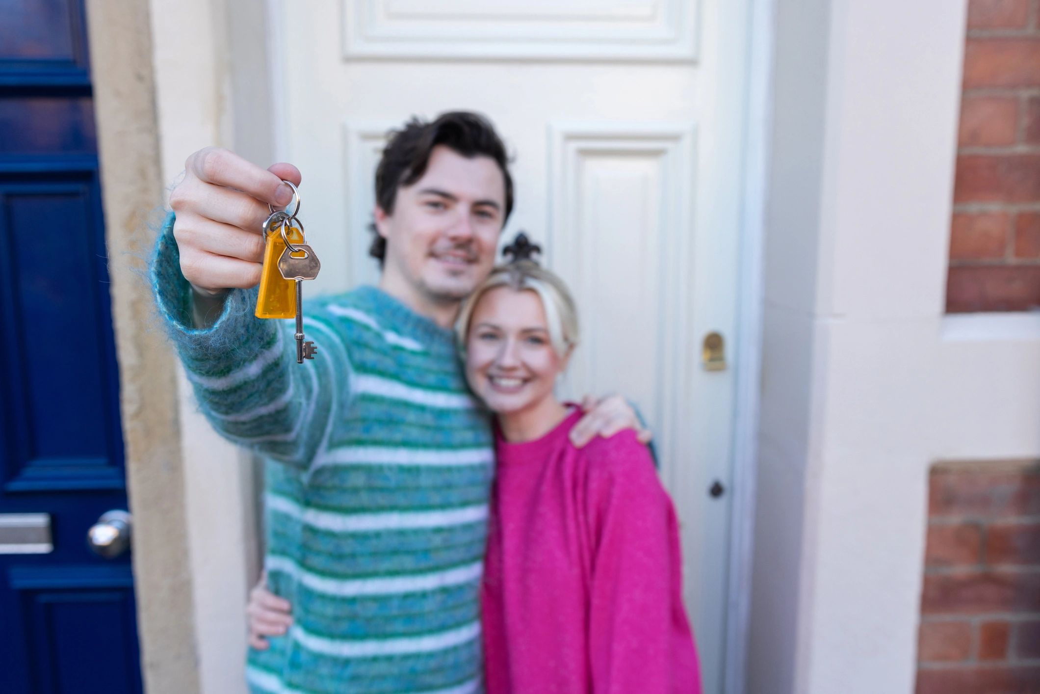 Couple holding keys outside their new home